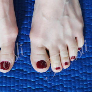 Nackte Füße mit roten Nägeln auf einer blauen Gymnastik-Matte