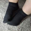 Zart duftende, getragene schwarze Socken mit sichtbaren Spuren eines langen Tages – weich, warm und bereit für neue Abenteuer.