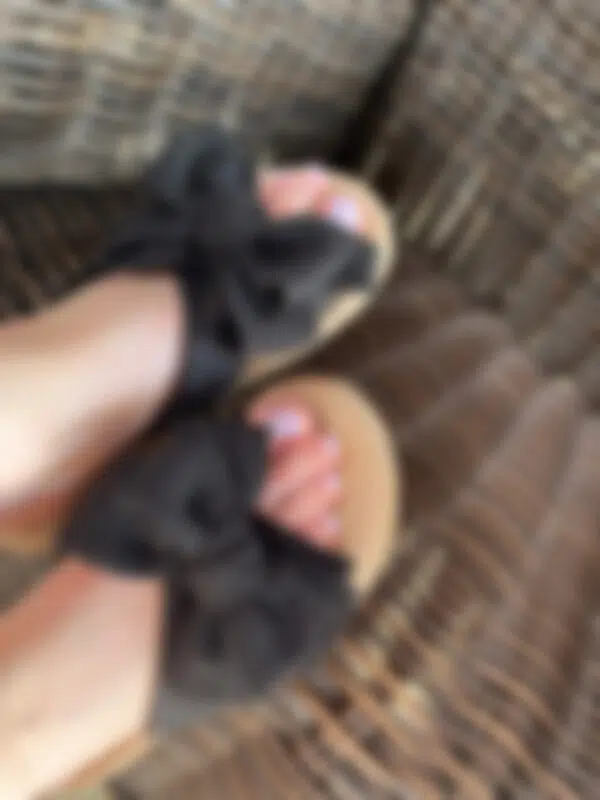 Schleifen Schuhe mit dezentem Nagellack auf den Zehen